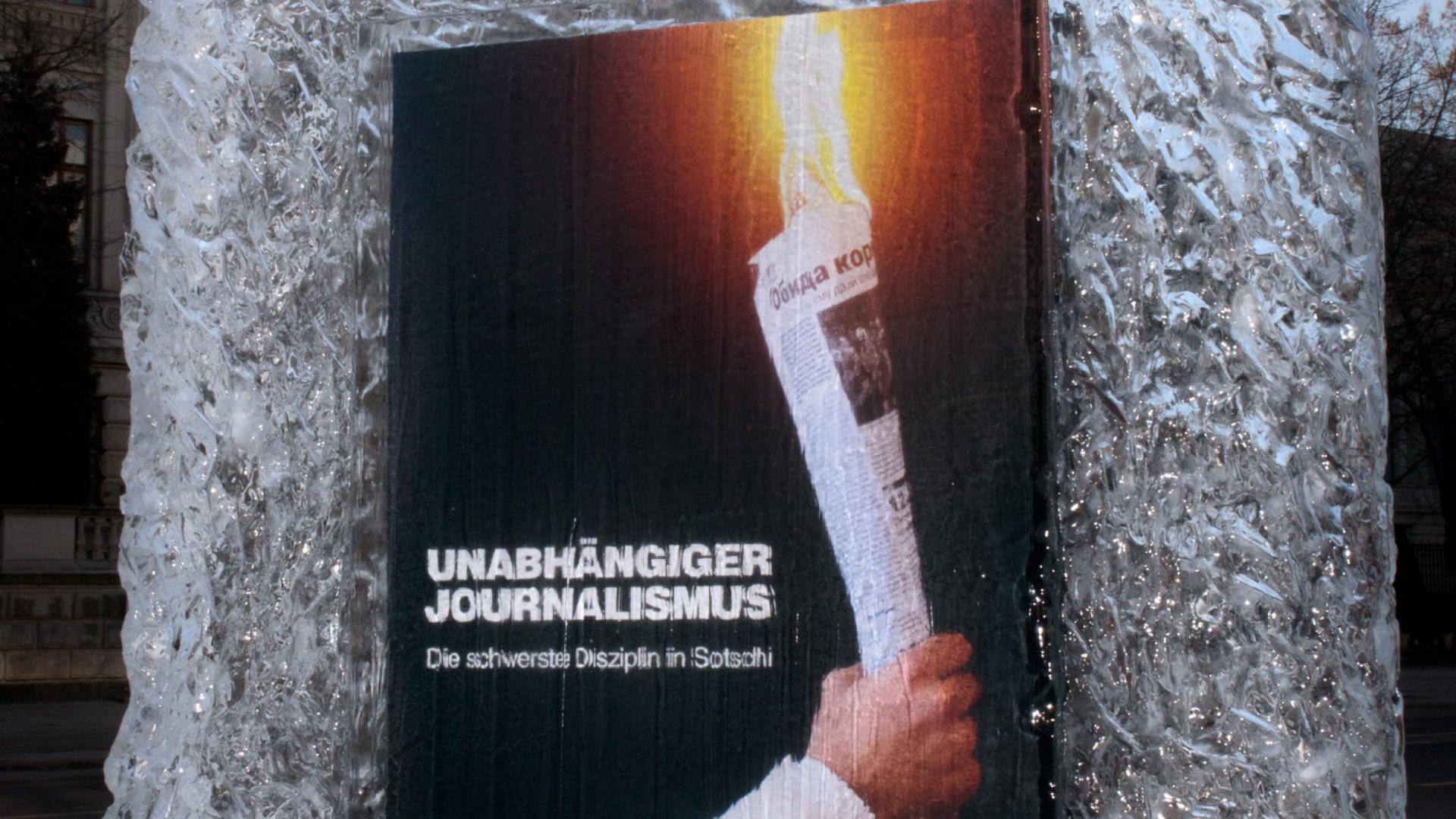 Ein Plakat mit einer brennenden Zeitung in Form einer Fackel ist vor der russischen Botschaft in einem Block eingefroren. Es trägt die Aufschrift "Unabhängiger Journalismus"