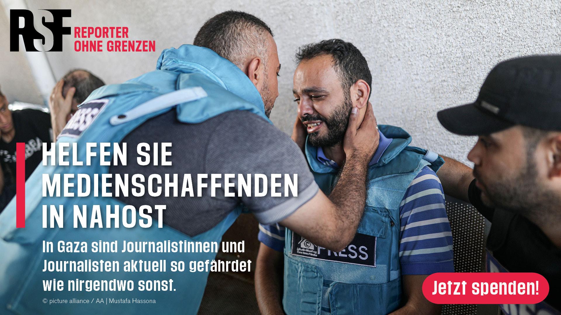 Helfen sie Medienschaffenden in Nahost-in Gaza sind Journalist*innen aktuell so gefährdet wie nirgendwo sonst. Bild: Ein mann hält einen anderen Mann am Kopf, beide tragen Presseschutzwesten