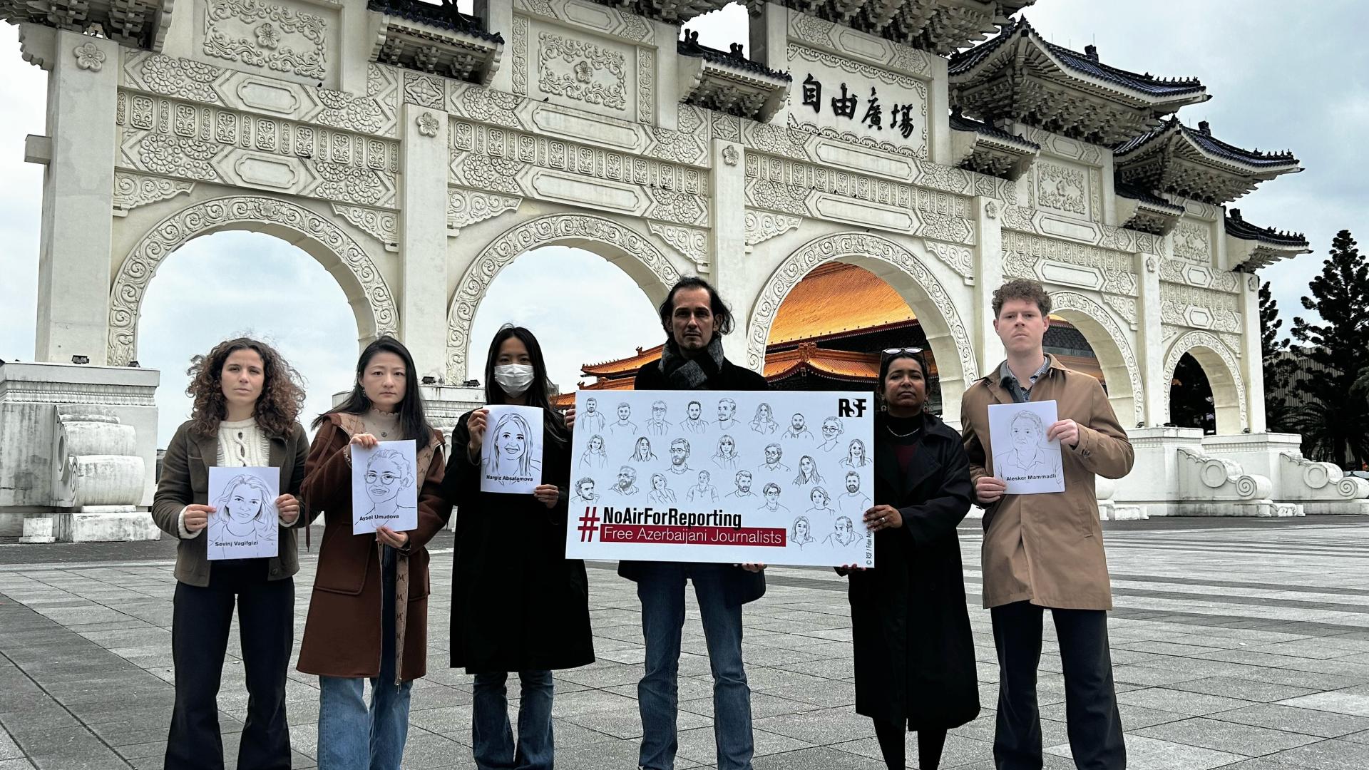 Sechs Personen mit Illustrationen und Solidaritätsposter auf dem Liberty Square in der taiwanesischen Hauptstadt Taipeh