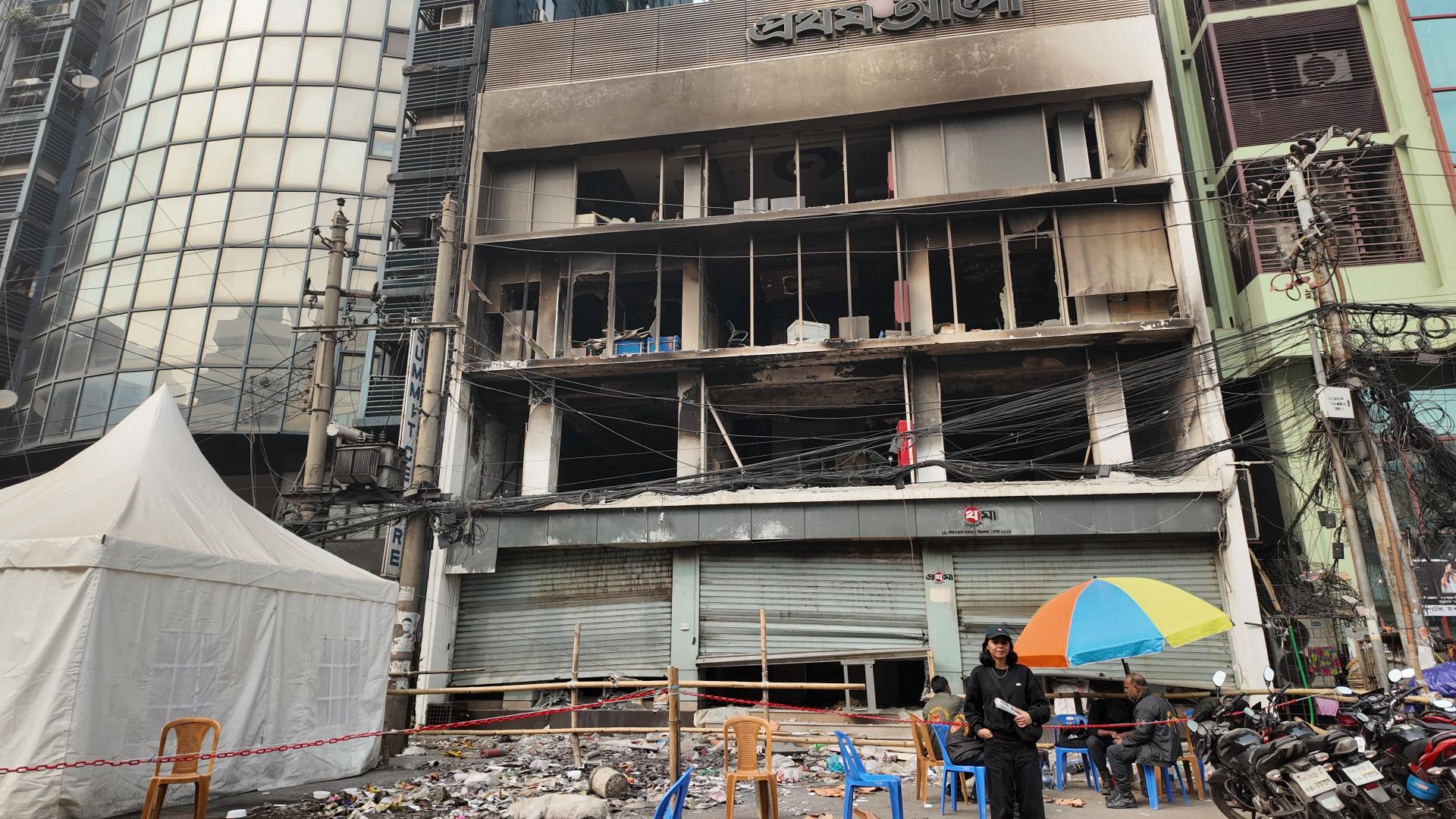 Shammi Haque steht vor dem verbrannten Gebäude der Zeitung Prothom Alo in Dhaka.