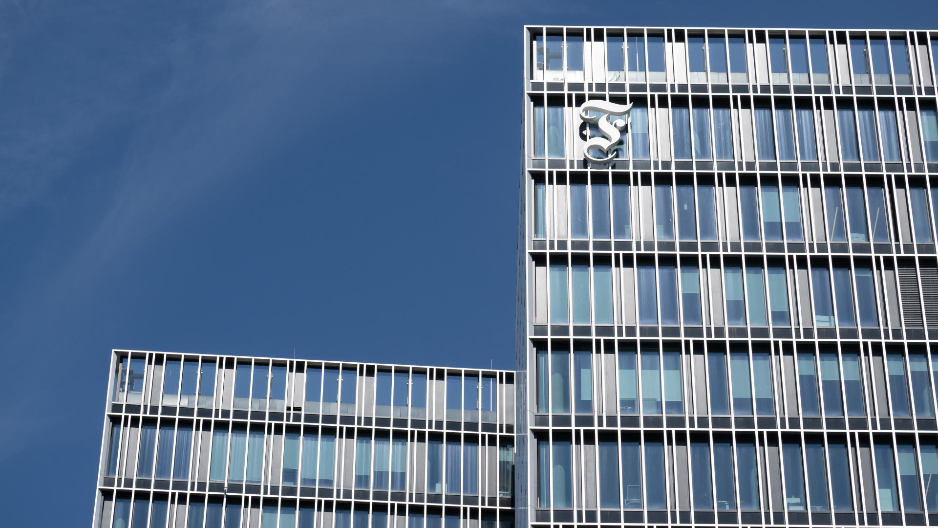 Das Bild zeigt ein Hochhaus mit einem großen "F" an der Vorderseite. 